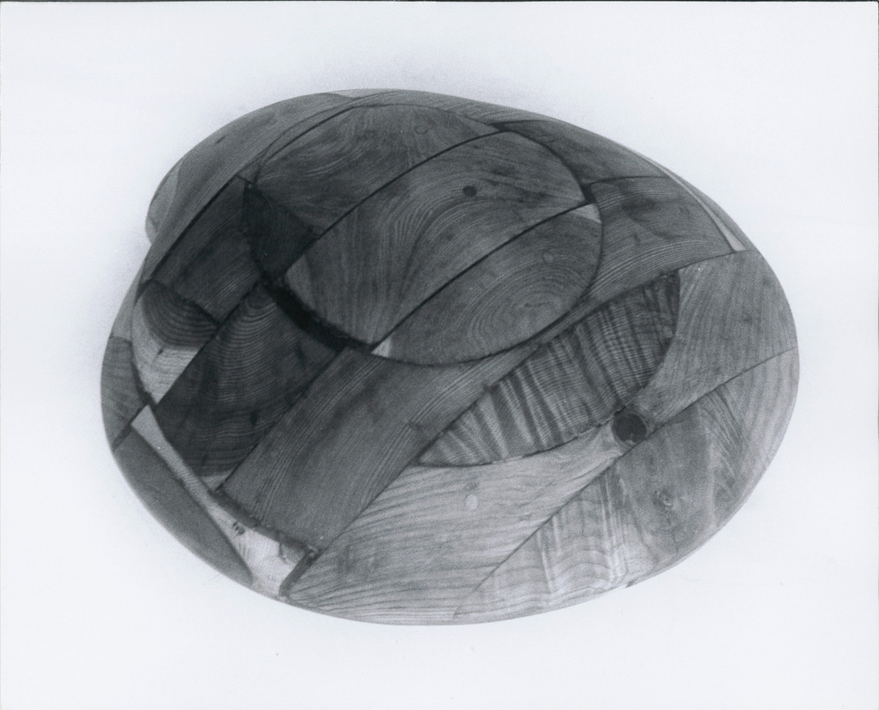 A black and white photograph of a wooden clam sculpture.
