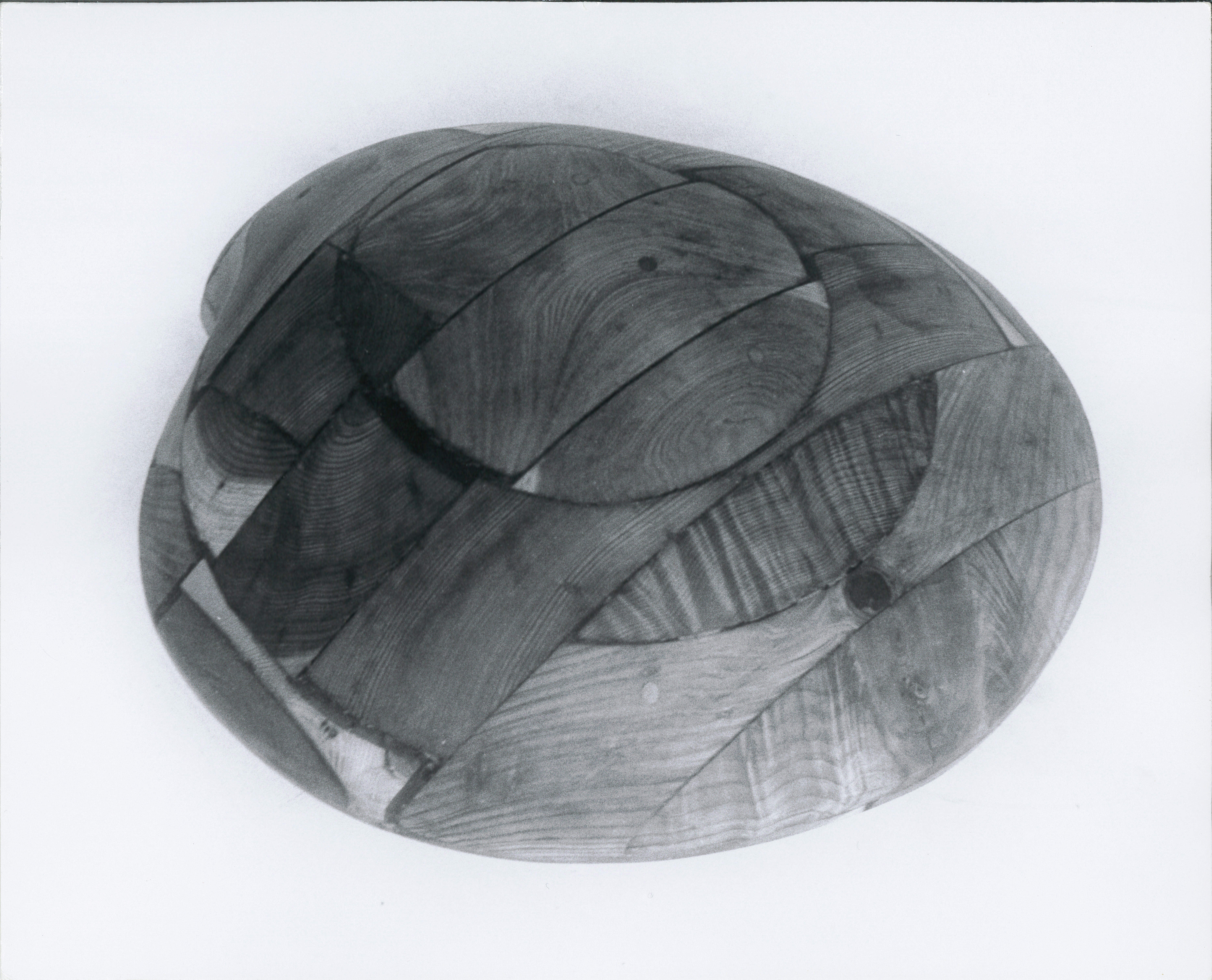 A black and white photograph of a wooden clam sculpture.