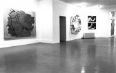 Sculptural and painted works appear in a white-walled gallery space.