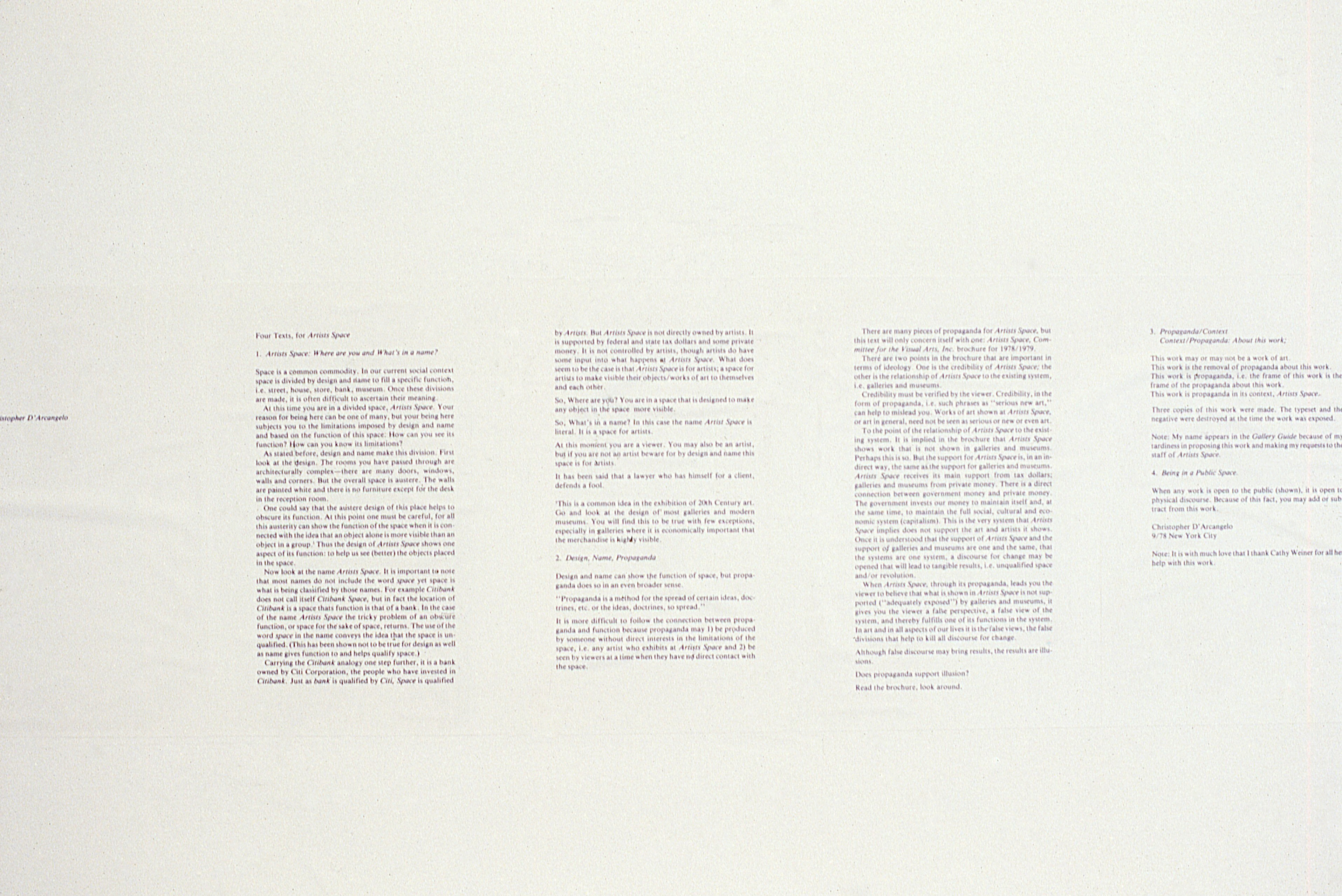 Sheets of text hang on a white wall. Text is too small to be legible.