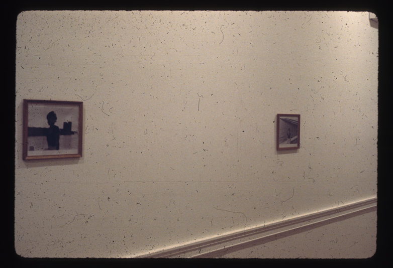 Two images hang on a white wall, far apart.