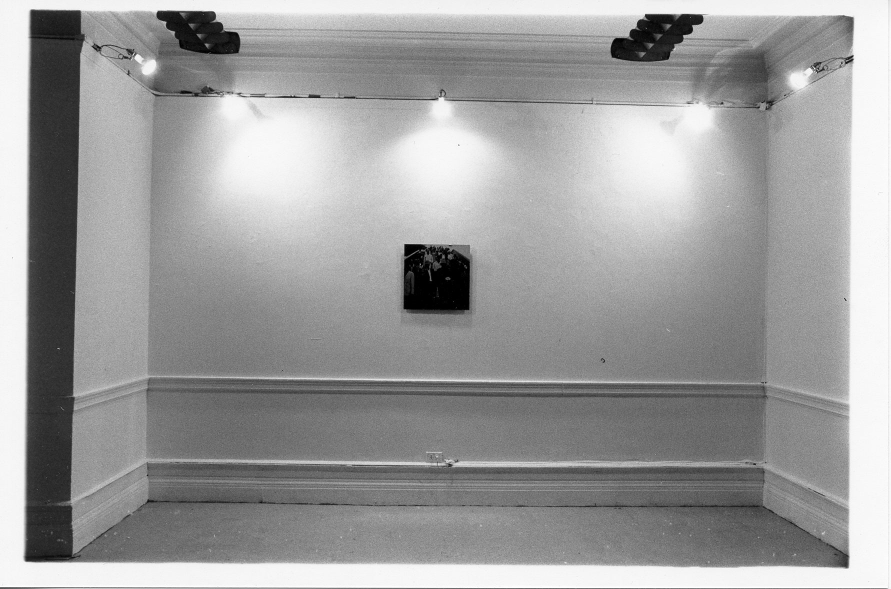 A single image hangs on a white wall.