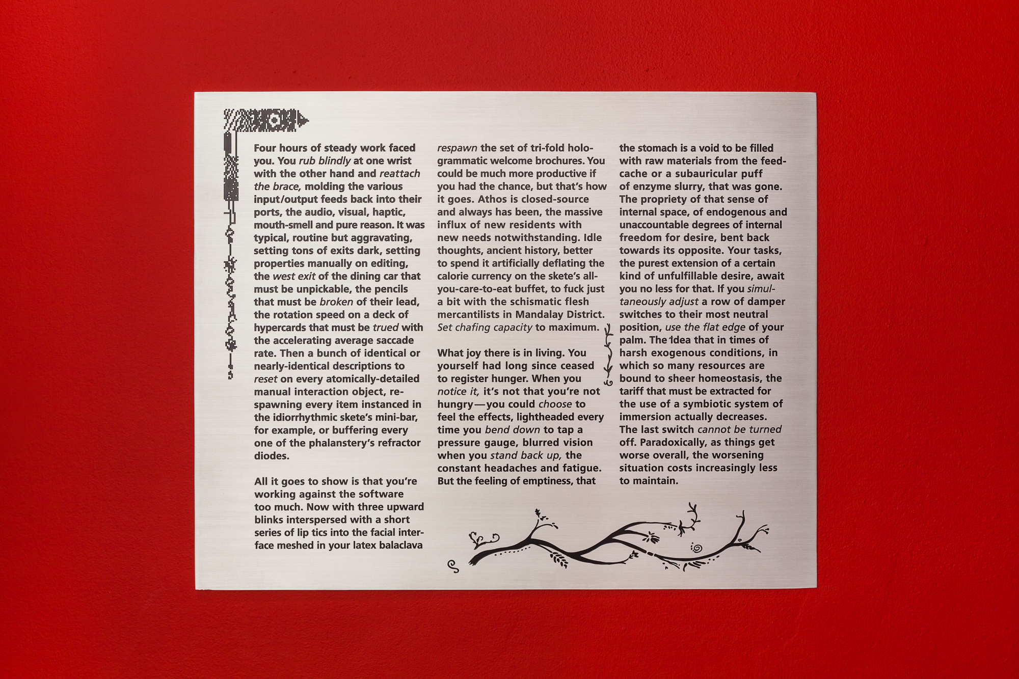 A silver, metal plaque displayed against a bright red backdrop. Text engraved on the plaque reads, 