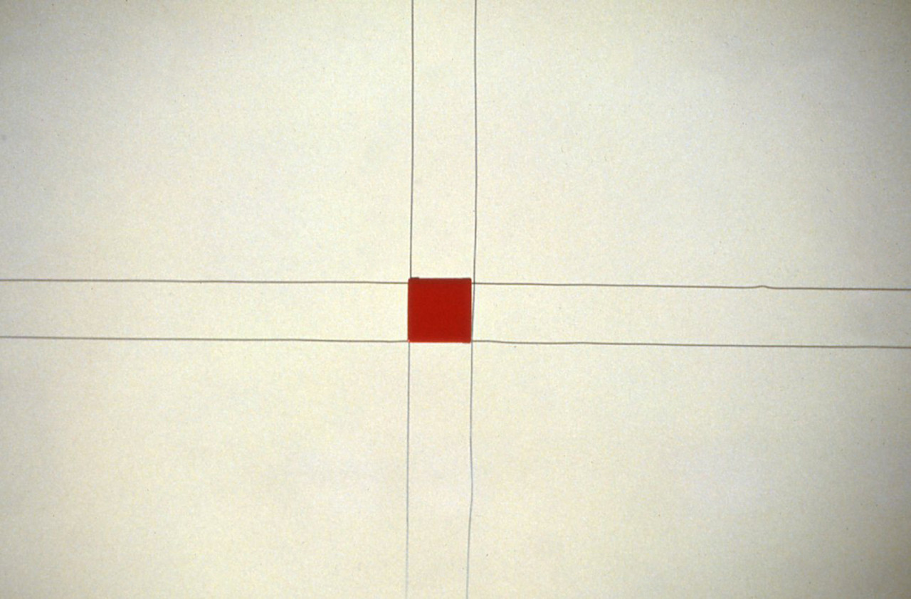 A gray cross made from wire on a white background, with a small, red square held in the center.