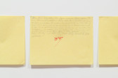 A photograph of three works on yellow paper hung on a white wall.