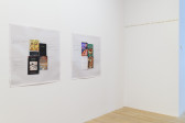 Two prints, of books with annotations written on the side, are hung on a white gallery wall.