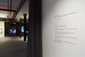 A close up image of vinyl text installed on a gallery wall. The header of the text reads, 
