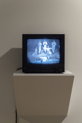 A television displaying a grainy black and white image of a group of people.