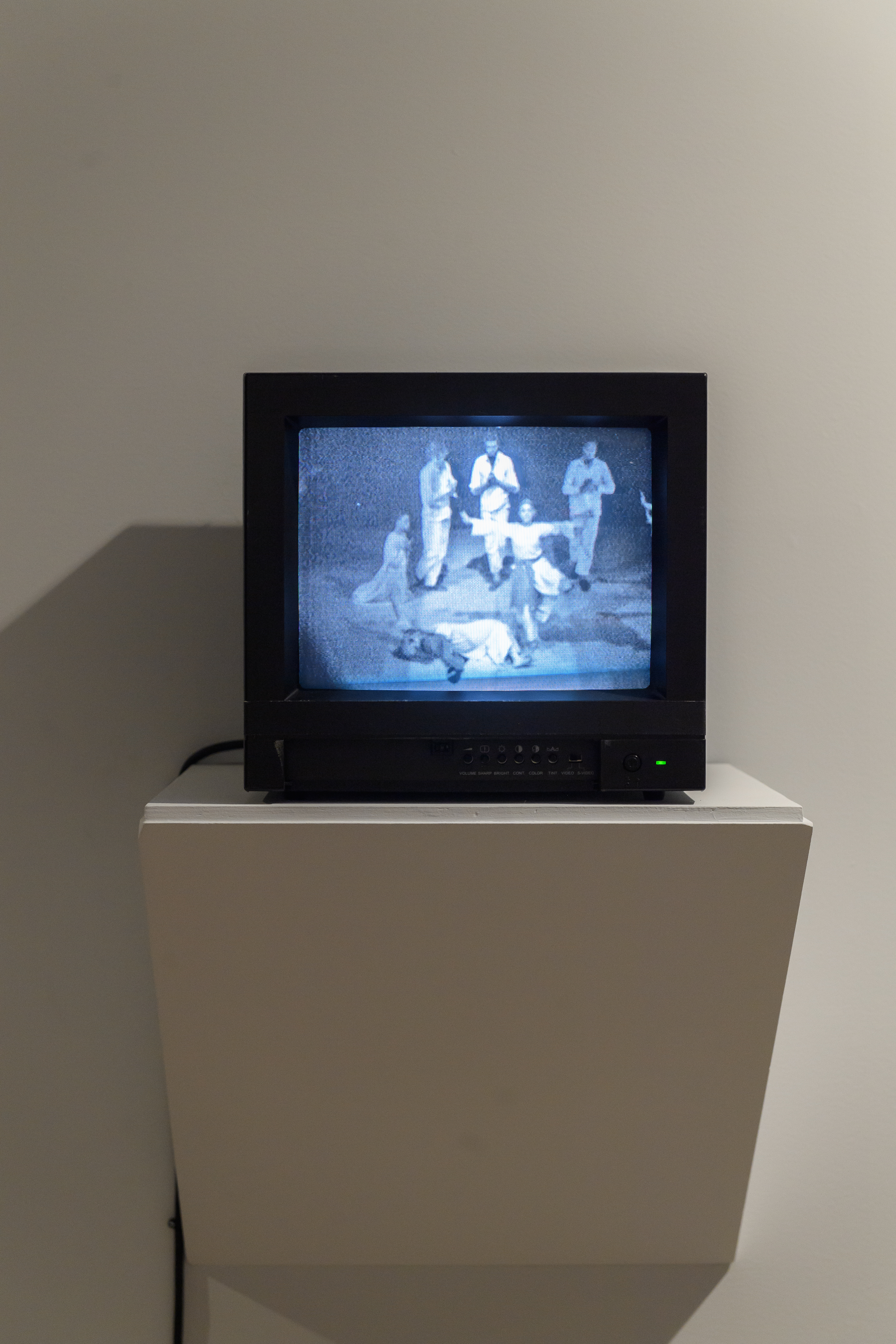 A television displaying a grainy black and white image of a group of people.