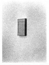 Blurry view of a painting hanging on a wall in gallery space.