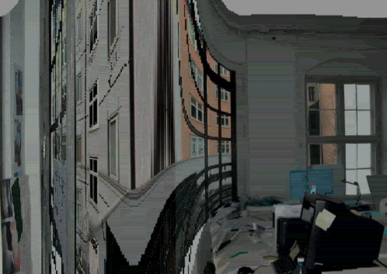 An extremely warped digital image of the interior of a messy office space facing a series of windows, through which the highly warped facades of city buildings are visible.