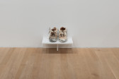 At the bottom of the gallery wall sits a small shelf housing a pair of construction boots that are extremely worn in and covered in white paint.