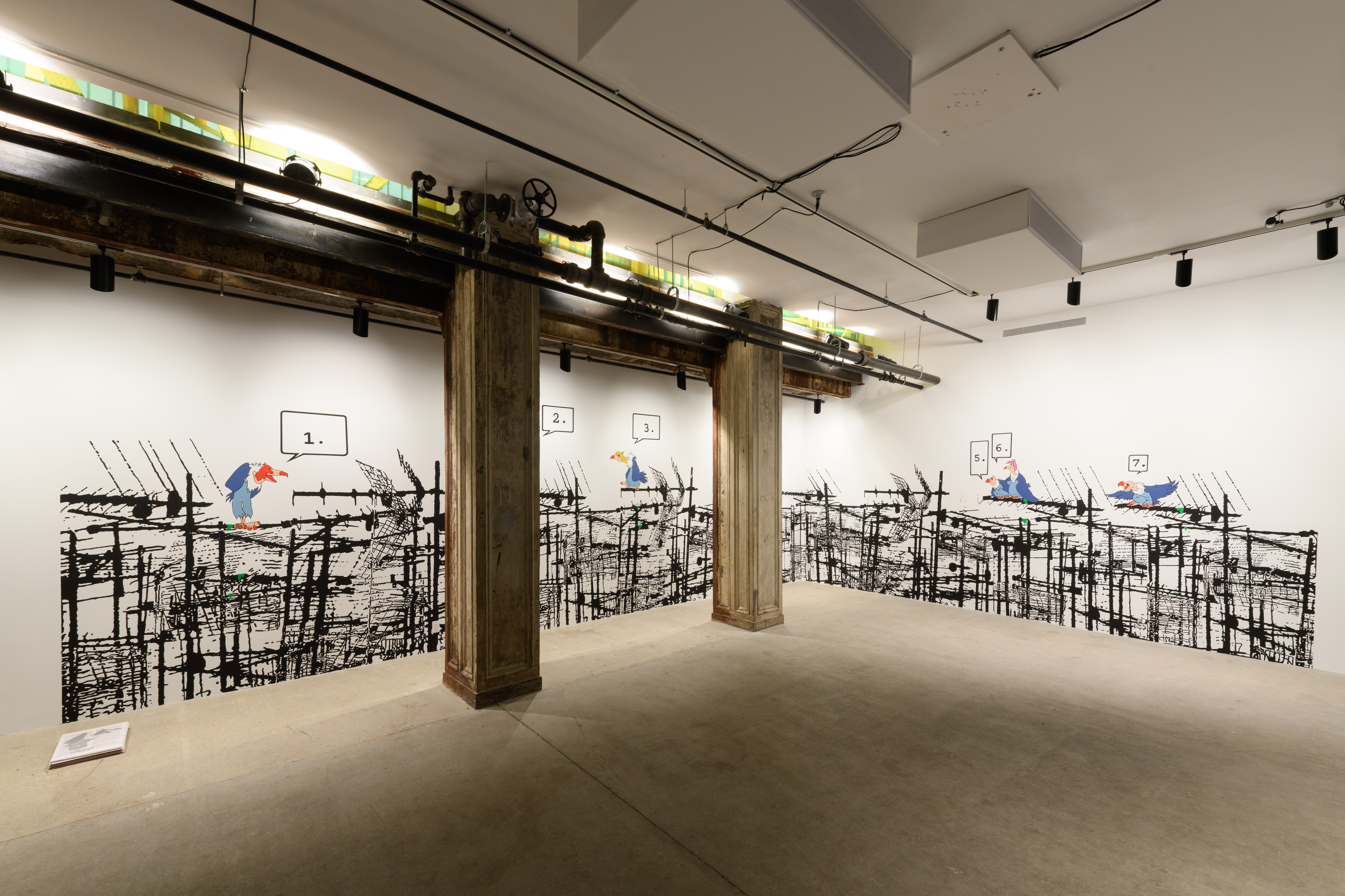 Behind two large columns is a wall mural displaying multiple cartoon vultures resting on black scaffolding. Beside the mural sits a pile of newsprint flyers.