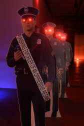 A view of four red-eyed police officer cardboard cutouts with sashes that read 