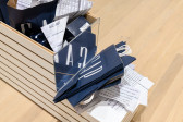 A close up of a store display planter stuffed with Gap clothing store bags and crumpled documents.