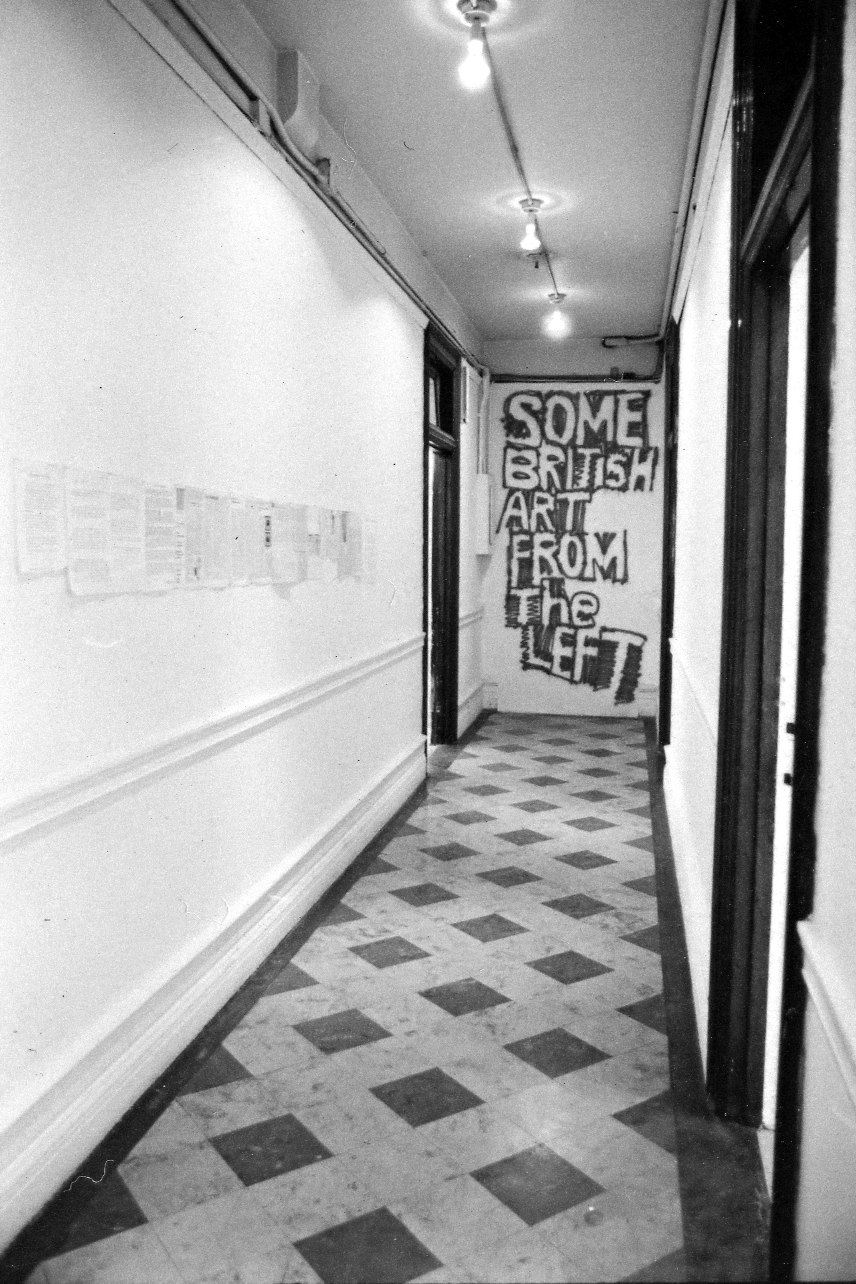 A photograph of a long corridor with a far wall with the words 