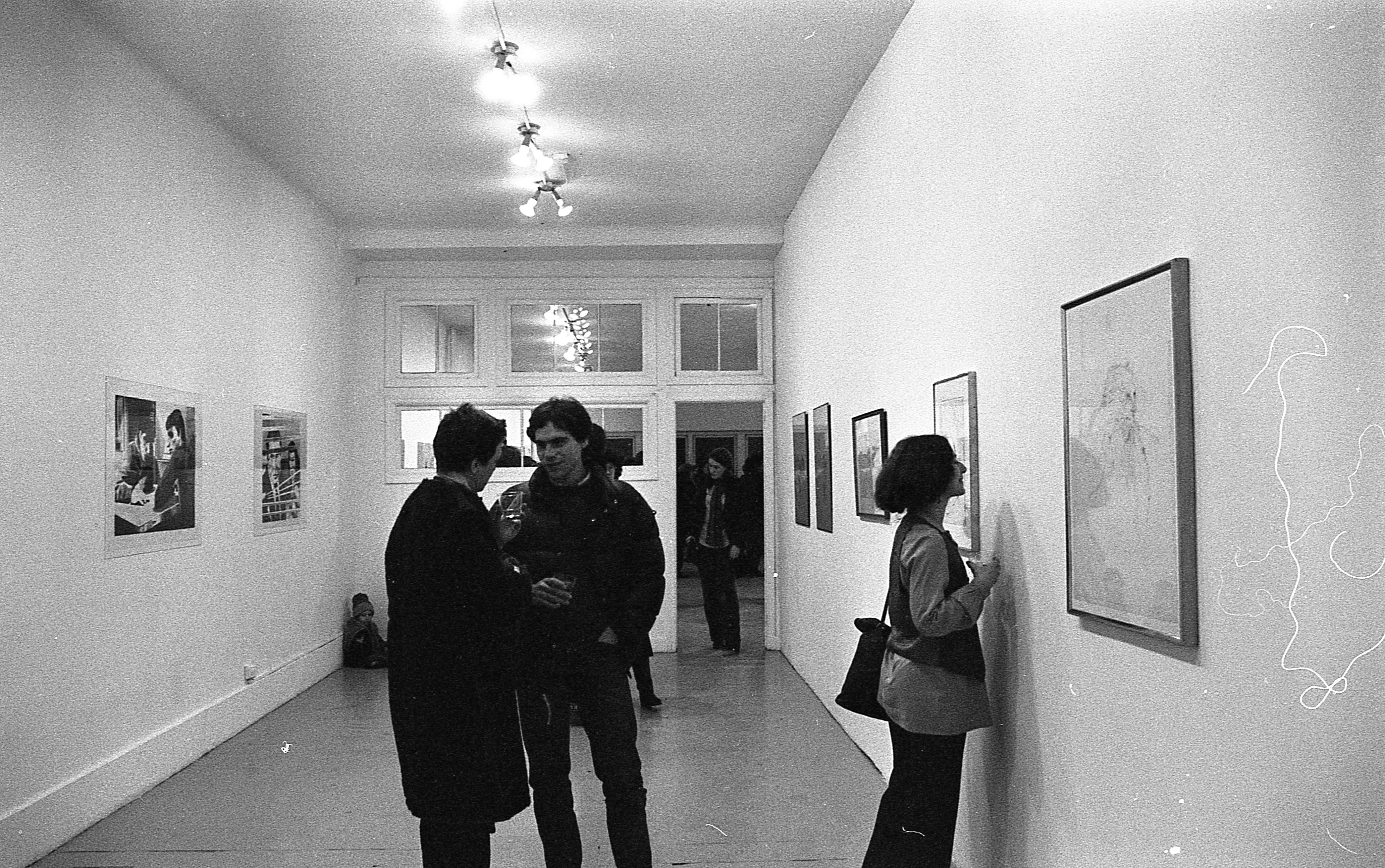 Various people having conversations and looking around at the art during the exhibition opening.