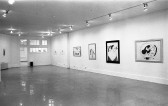 A large open space with drawings hung up on the walls. One drawing shows a woman surrounded by musical notes. Another shows a woman's profile with a pipe in her mouth.
