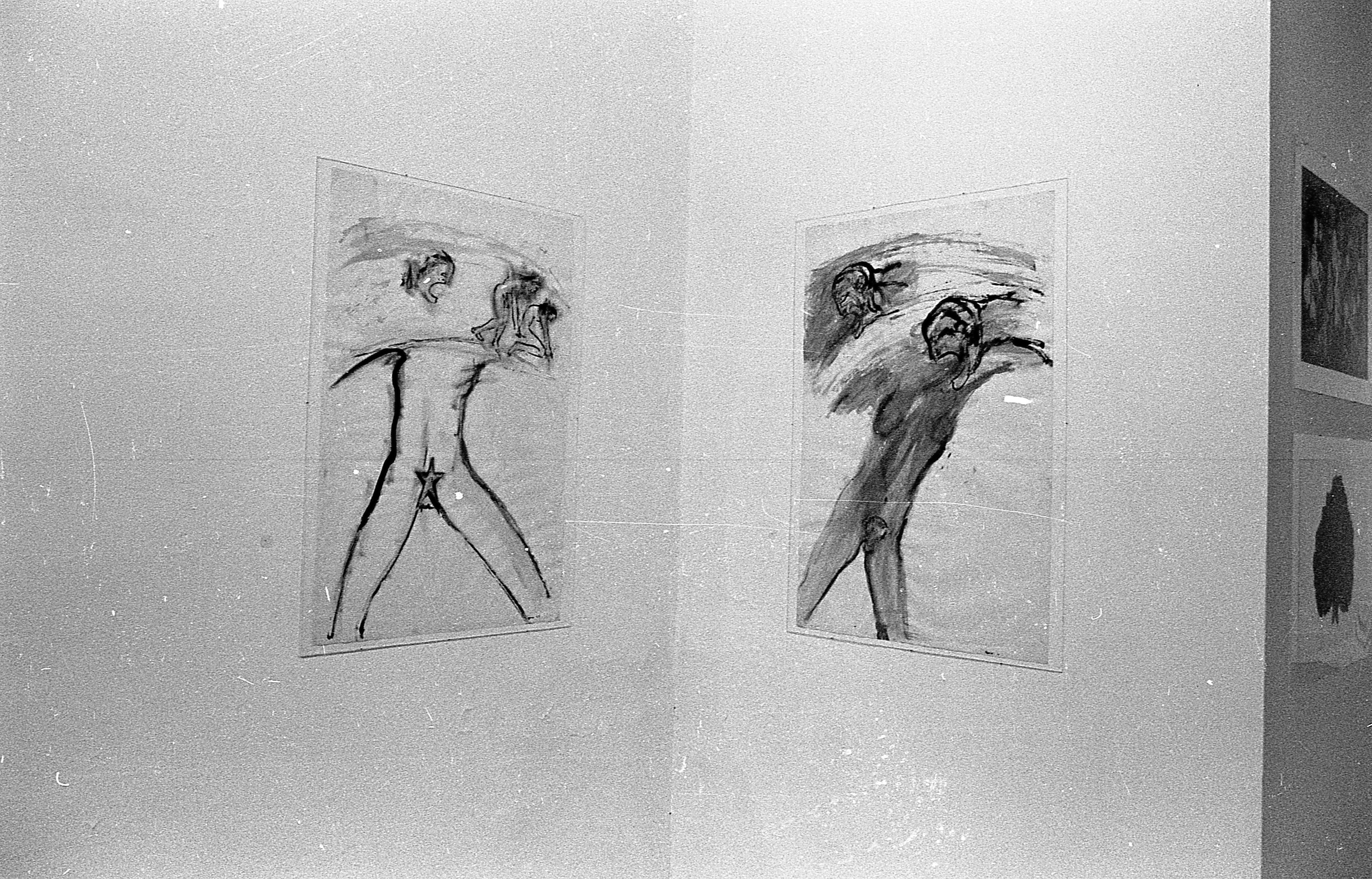 Two drawings hung up on adjacent walls. On the left is a nude headless figure with a star covering its groin and smaller figures walking along the top. On the right is a nude headless figure with two disembodied heads floating nearby with long extended tongues.