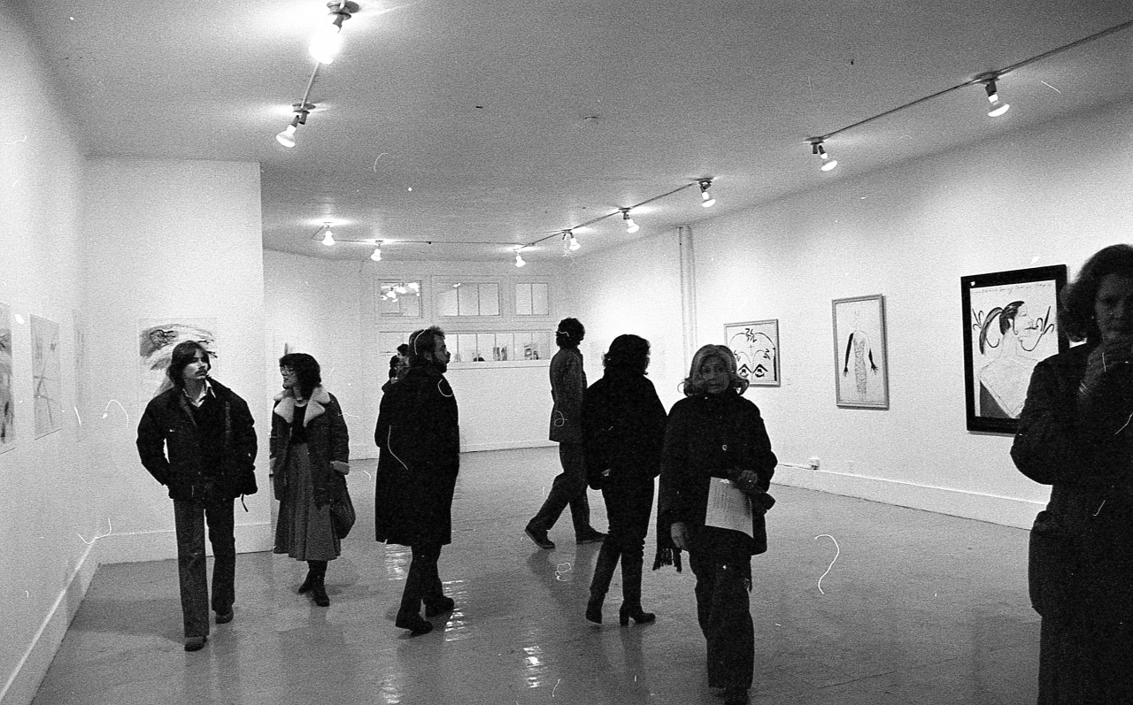Various people having conversations and looking around at the art during the exhibition opening.
