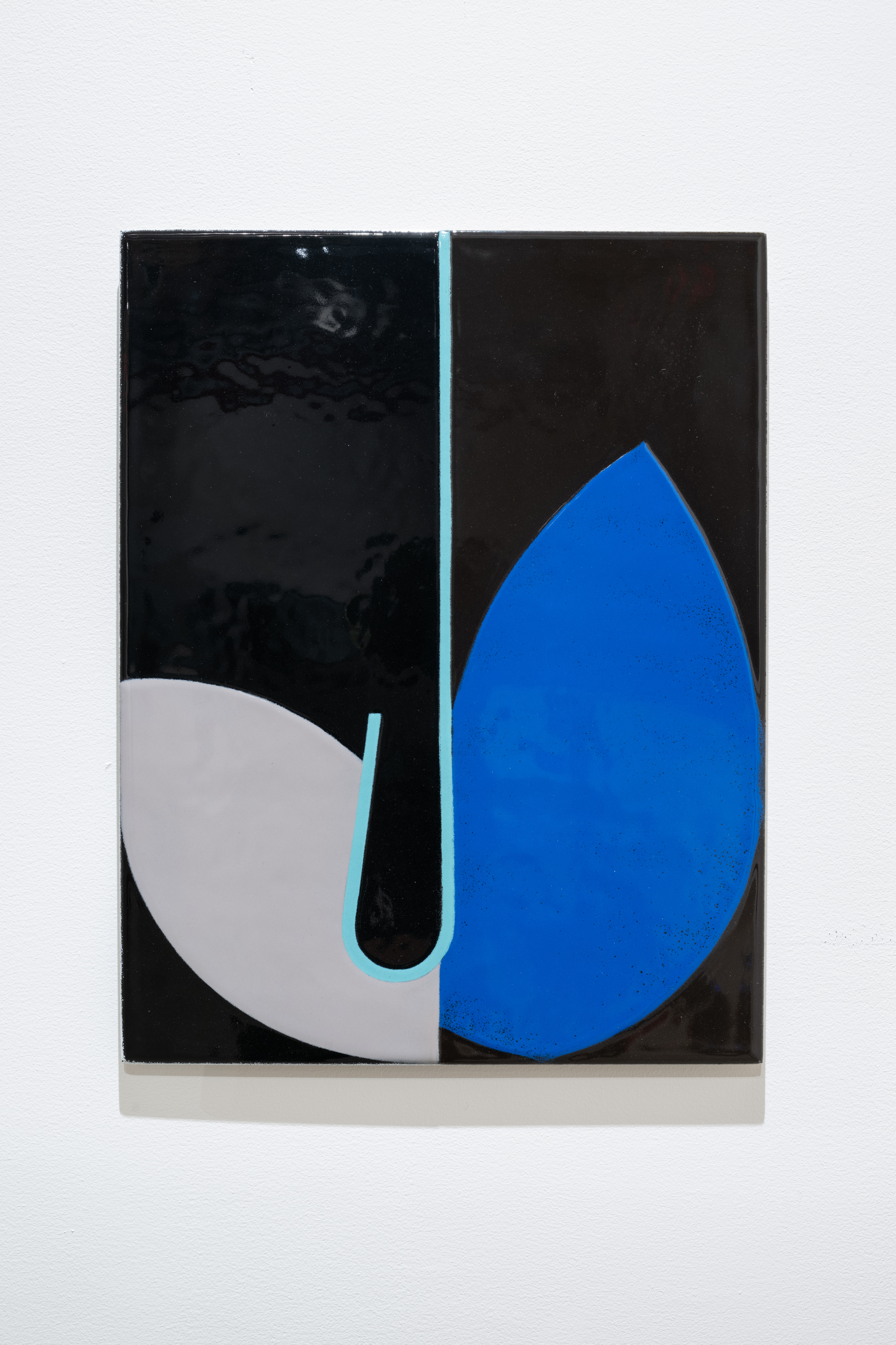 Color image of an abstract work, of black enamel on steel, with a light blue line running down the middle, a light grey petal on one side, and a bright blue petal on the other side.