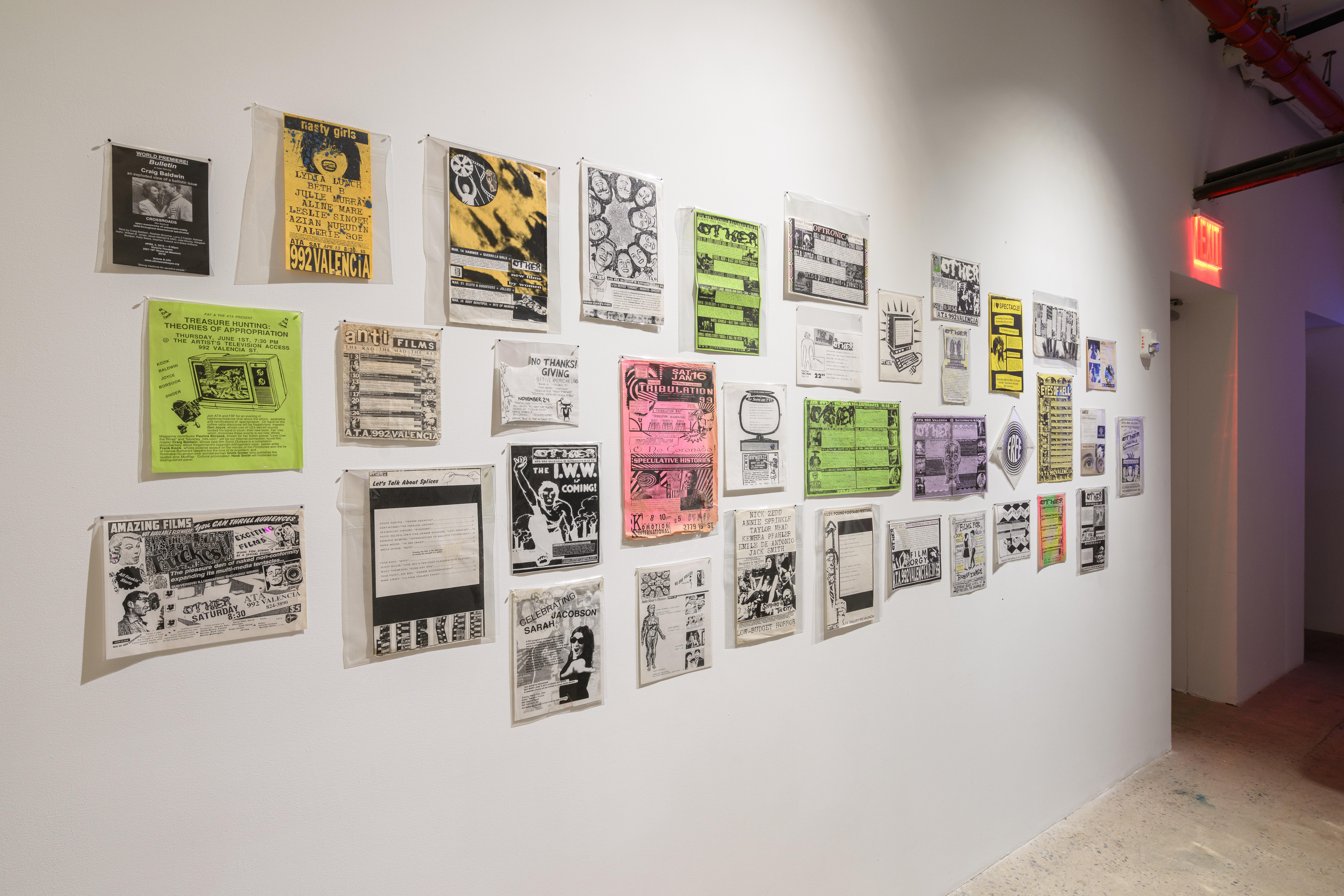 An image of a brightly lit wall, upon which various ephemera are mounted.