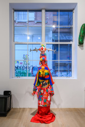 A life-sized costume in front of a large glass window.