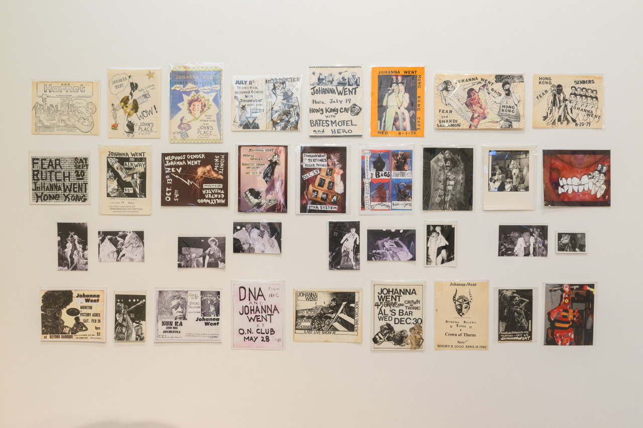 A wall that has various posters, photographs, and collages hanging from it.