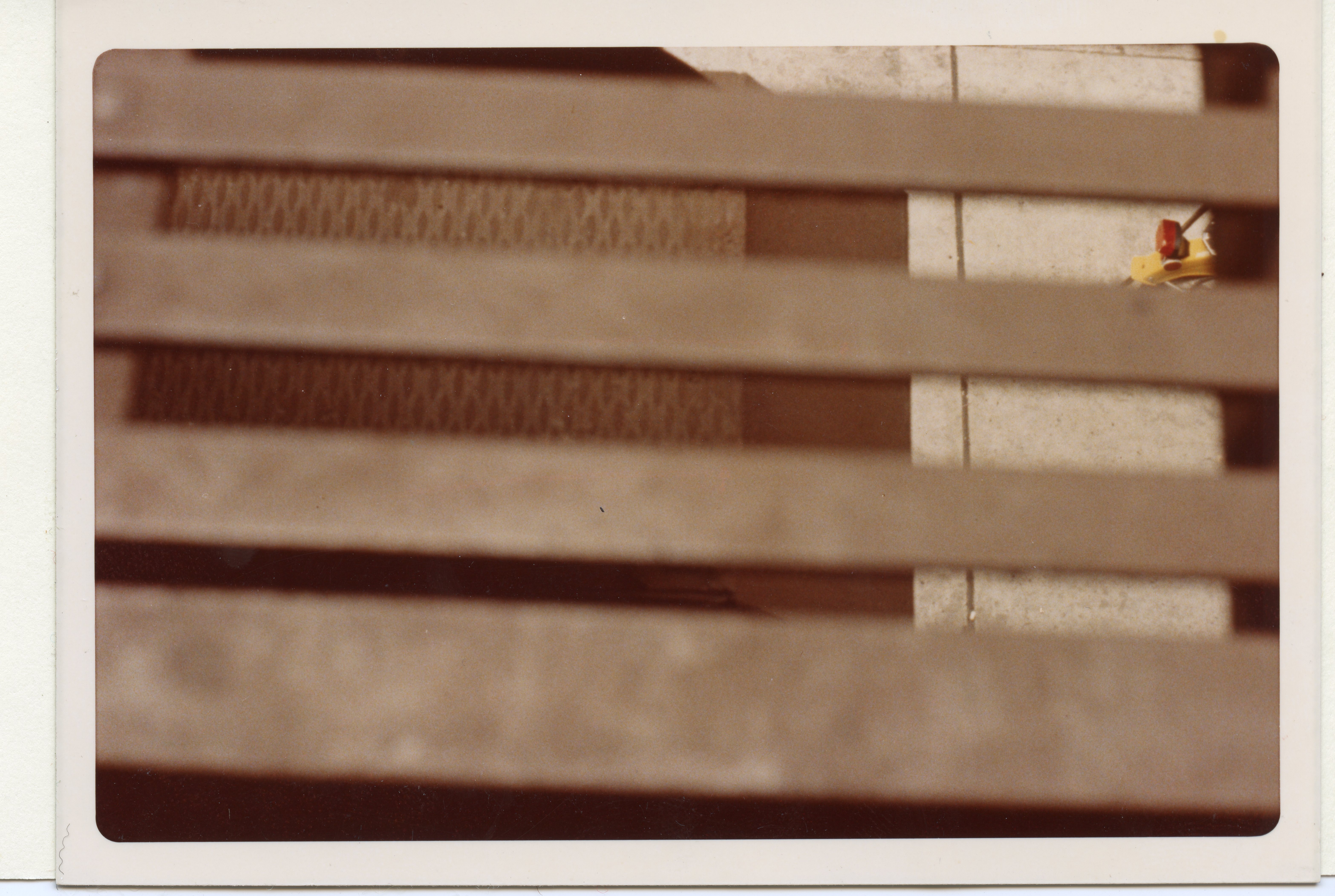 A view of a city street and the tail end of a bicycle is obscured by window blinds.