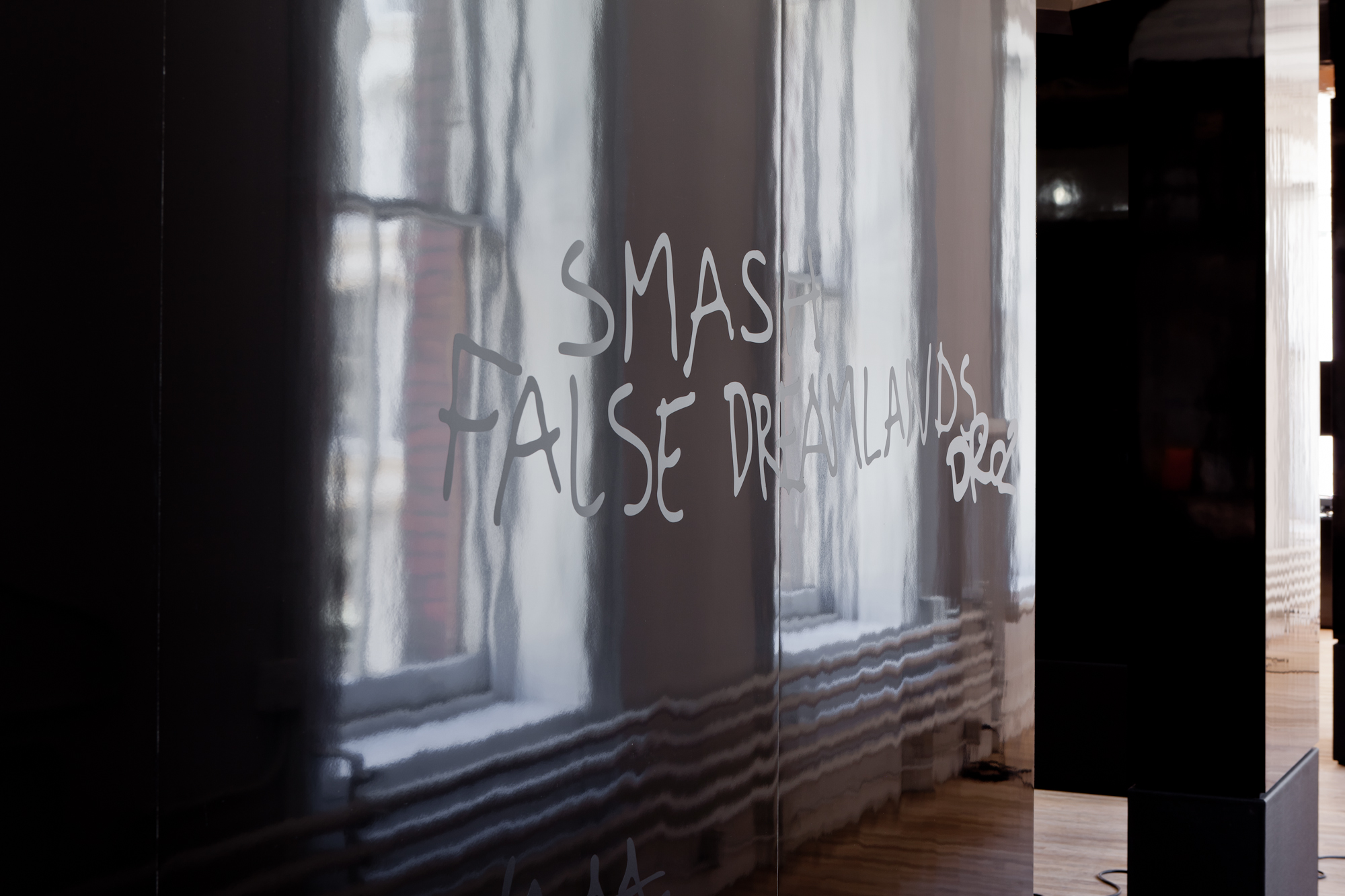 Detail view of white lettering on a black glossy structure: 