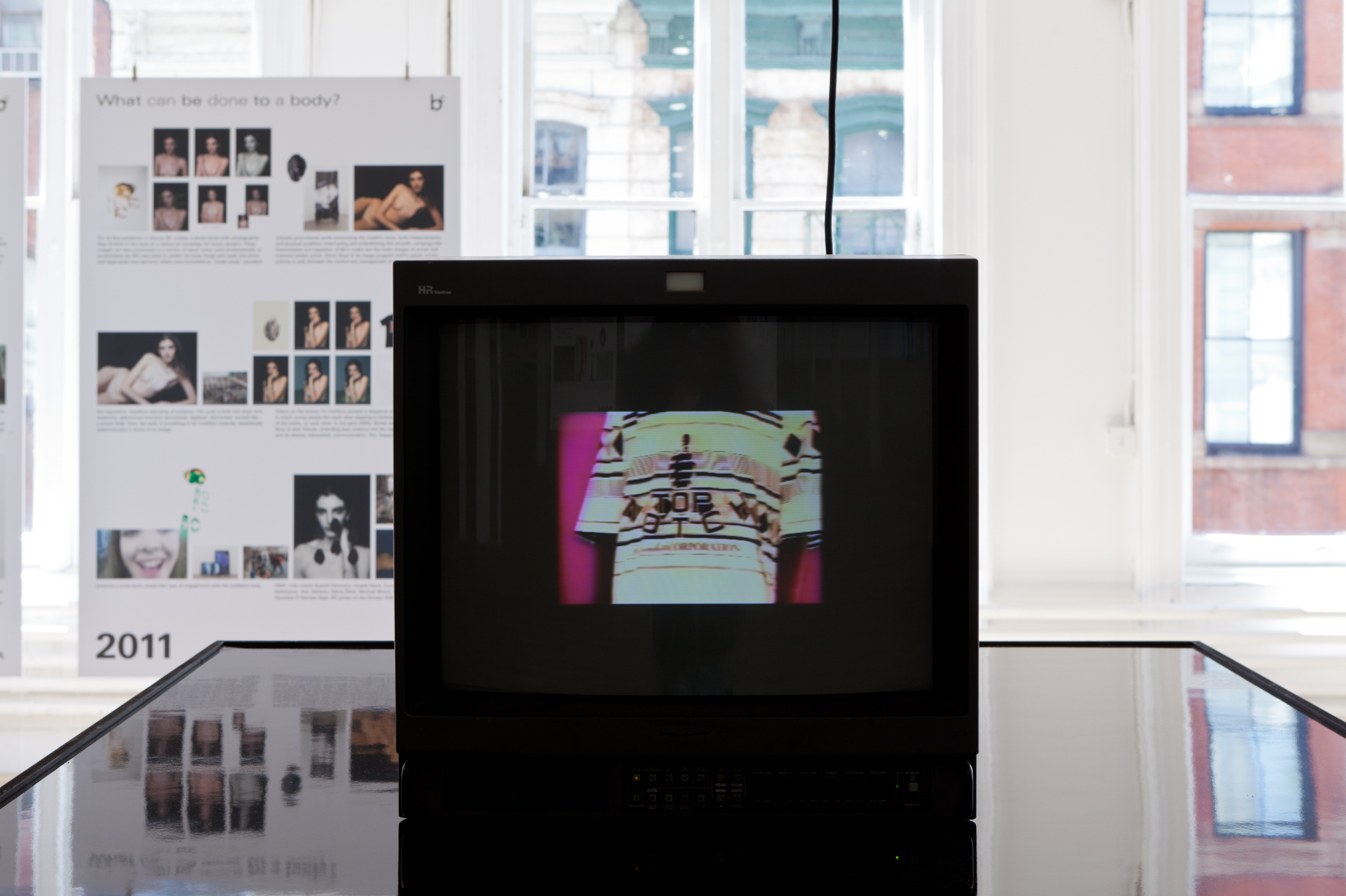 Detail view of a black platform with a black screen at the end, depicting a person wearing a shirt