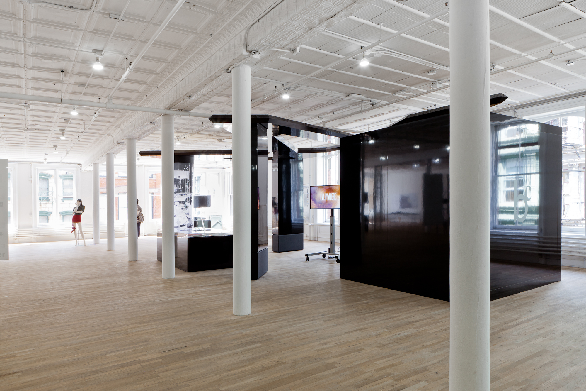 Overview of a large black glossy structure built in a gallery. The 