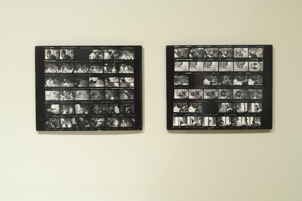 A close up image of two black and white contact sheets mounted on a wall.