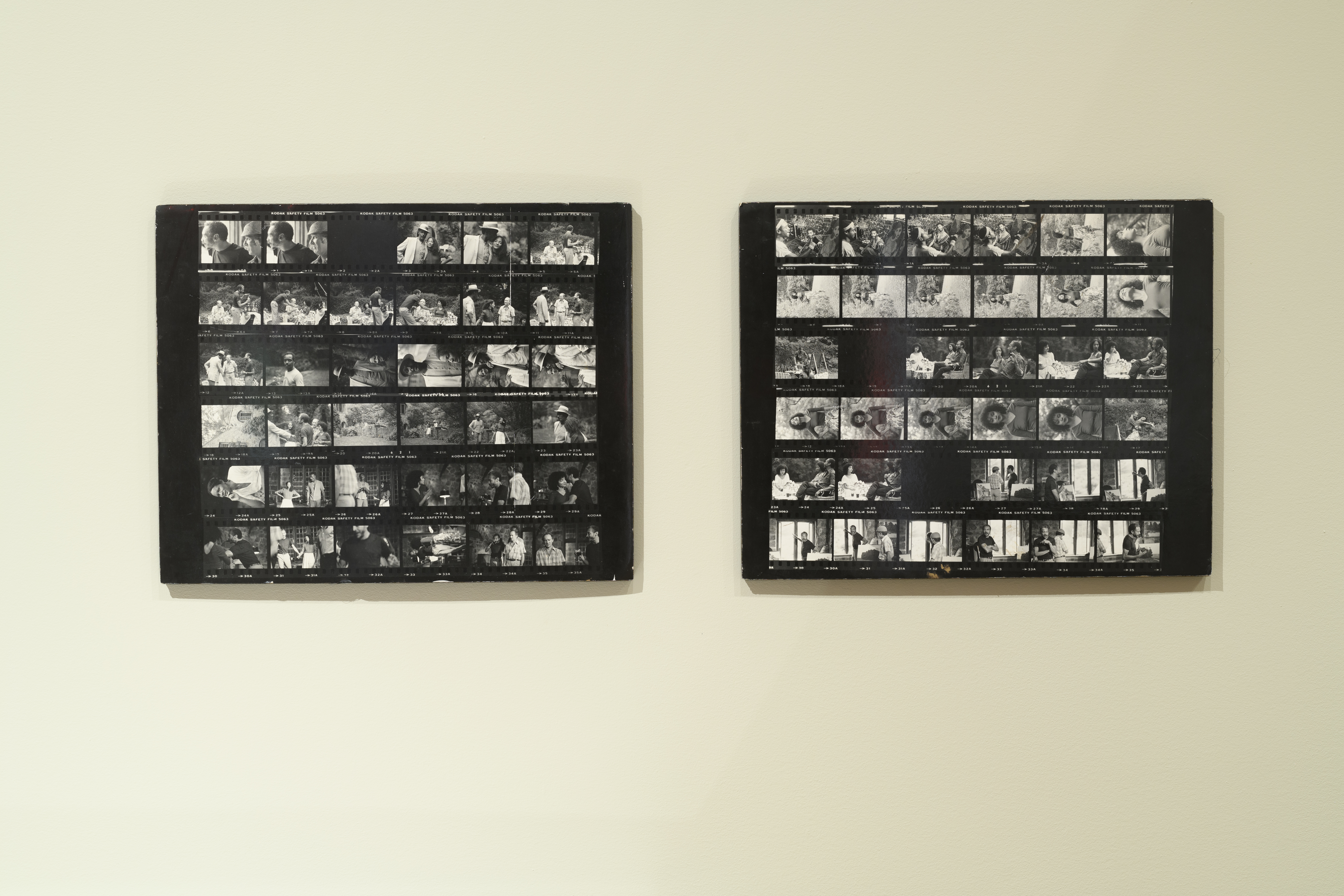 A close up image of two black and white contact sheets mounted on a wall.