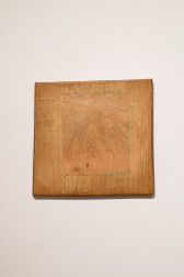 A smaller wooden panel has been inserted into a larger surrounding wooden square. The woods' grains contrast with slight color variations. 