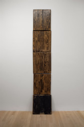 Five wooden panels stack atop one another to vertically scale the wall.