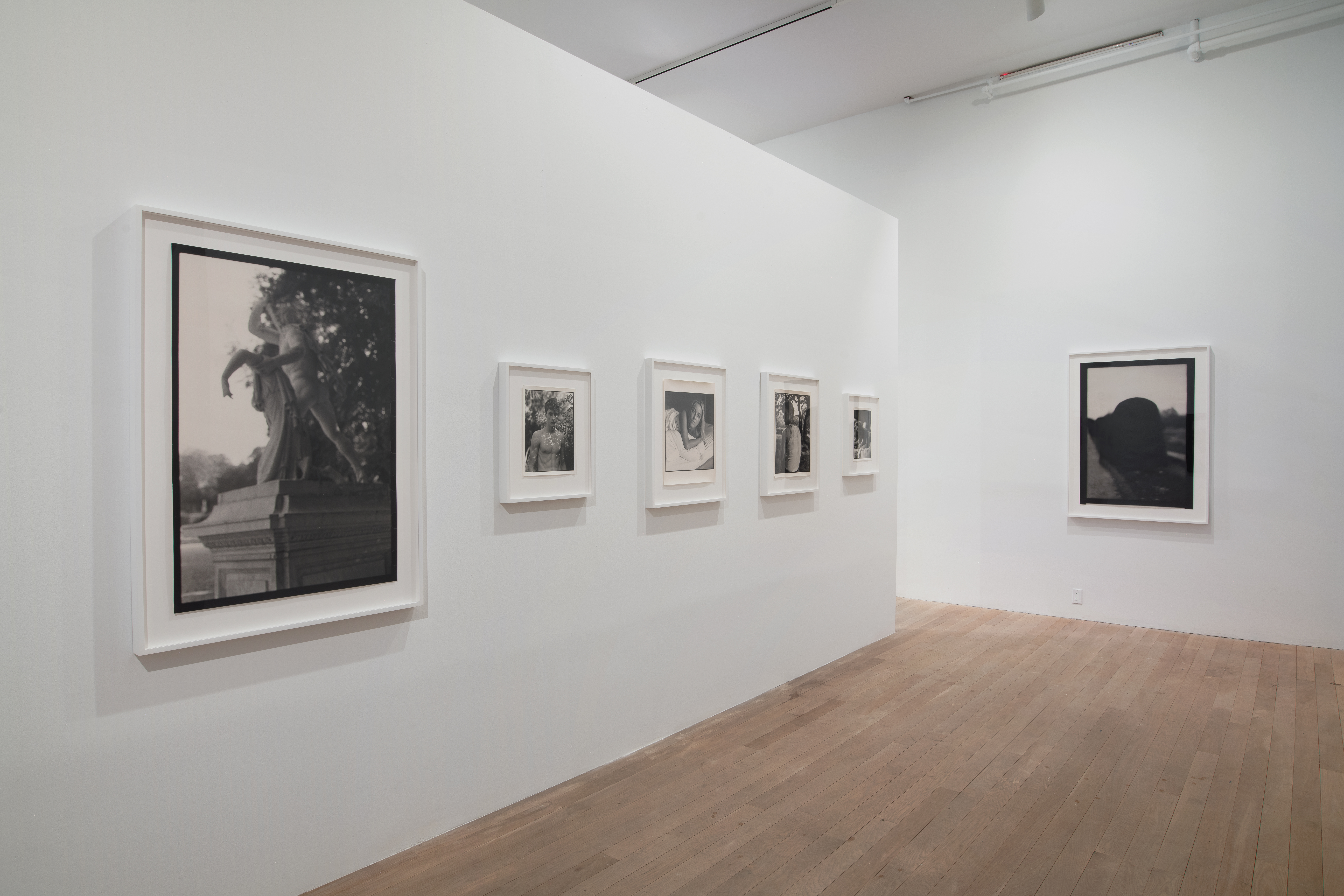 Two gallery walls display black and white images of various sizes. 
