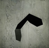 A black and white photograph of a dark geometric painting over a wooden background.