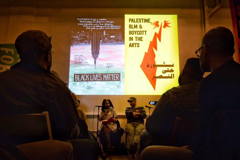 A projection on the wall displaying two posters, one that reads 