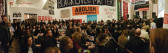 A panoramic image of the audience at Artists Space and Decolonize This Place's event, featuring colorful banners on the wall that read 