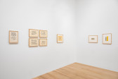 View of two white gallery walls featuring small framed works on paper, each featuring abstract calligraphic ink drawings.
