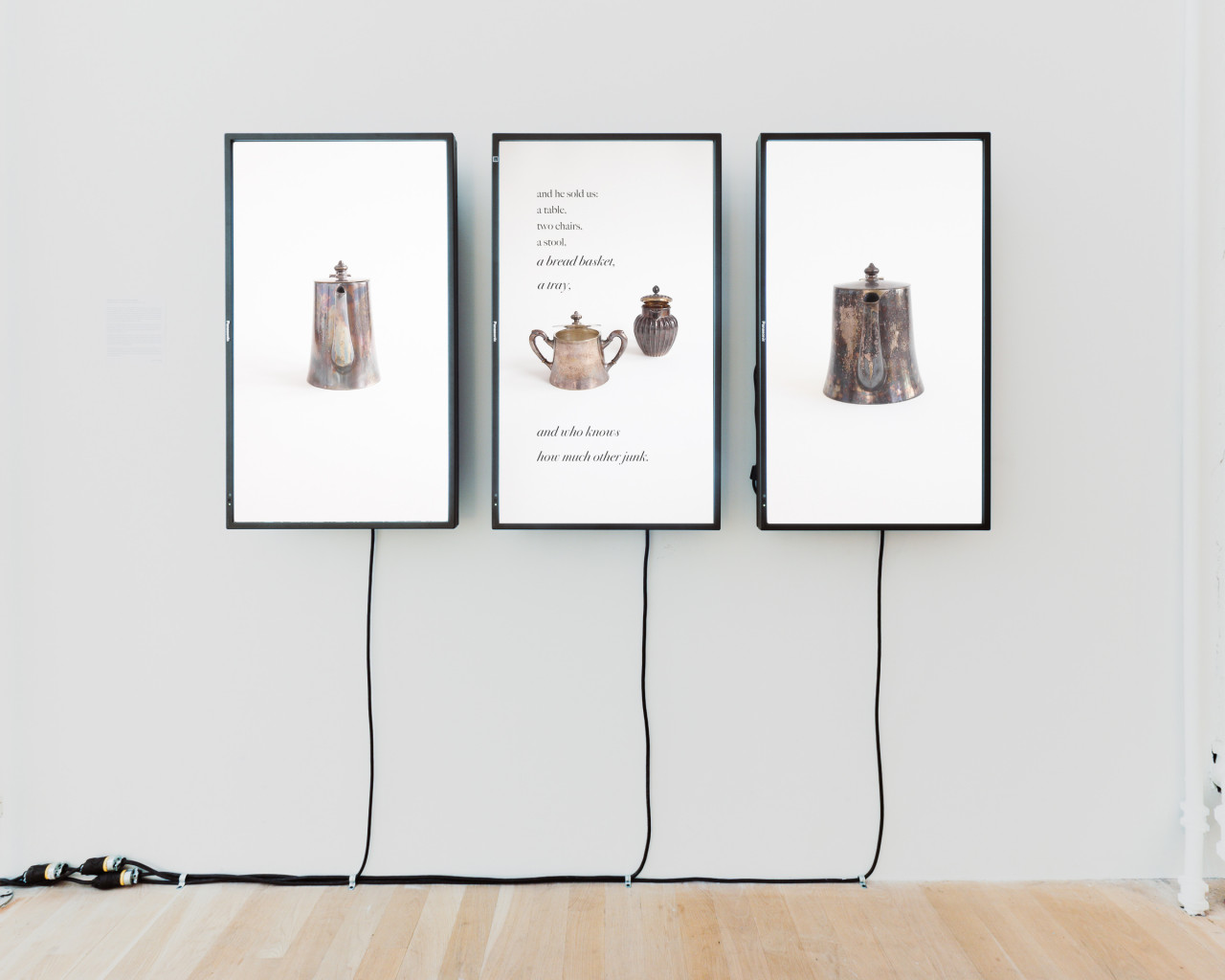An image of a video work with three vertical wall-mounted monitors, each with differently shaped kettles on them.
