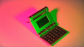 An open folding calculator, turned on its side and illuminated by bright green, peach, and pink lights.