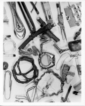 Wires, matches, sticks, bits of string, and other scrap metal pieces are strewn across a white background.