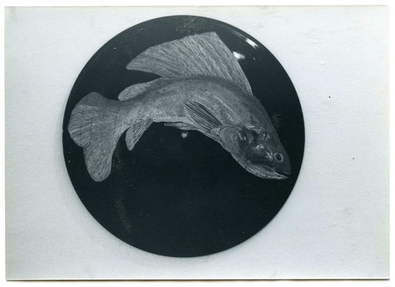 A black and white image of a black circle with a fish painted on it.