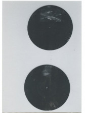 A black and white photograph of two black circles on a dark background.