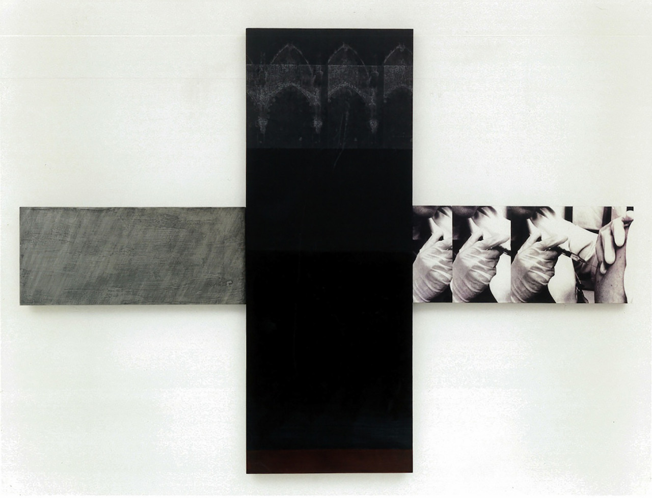 A cross-shaped panel installed on a white wall. The left arm of the panel is painted gray, while its vertical bisector is painted a dark black color. The right arm of the panel features a collage of three identical black and white images of a doctor wearing protective gloves while injecting a figure's arm with a syringe.