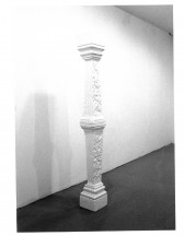 A black and white image of a column-like sculpture displayed in the exhibition space.