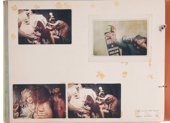A light colored paper with four photographs. Two images are the same, which feature a scene involving people and various props. The photograph at the top right features a man with a blue face posing next to a black and red sign. The image at the bottom left includes three people posing near one another.