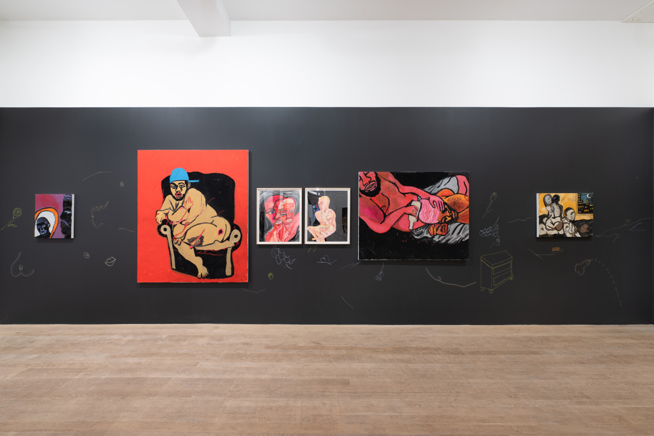 A color image of one wall of a gallery space, shot head-on. The wall is painted black, and six colorful, and intimate paintings of Black Queer figures are arranged across it. White and yellow drawings are pained onto the wall, complementing and placed around the artworks.
